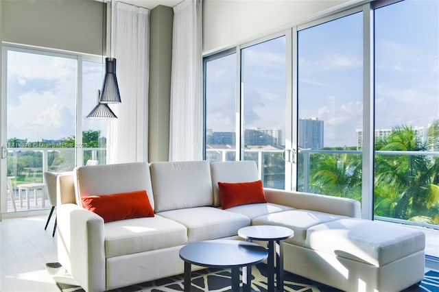 living room featuring light tile floors, a healthy amount of sunlight, and a wall of windows