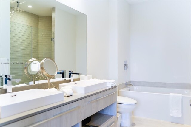 bathroom with a tub, toilet, and double sink vanity