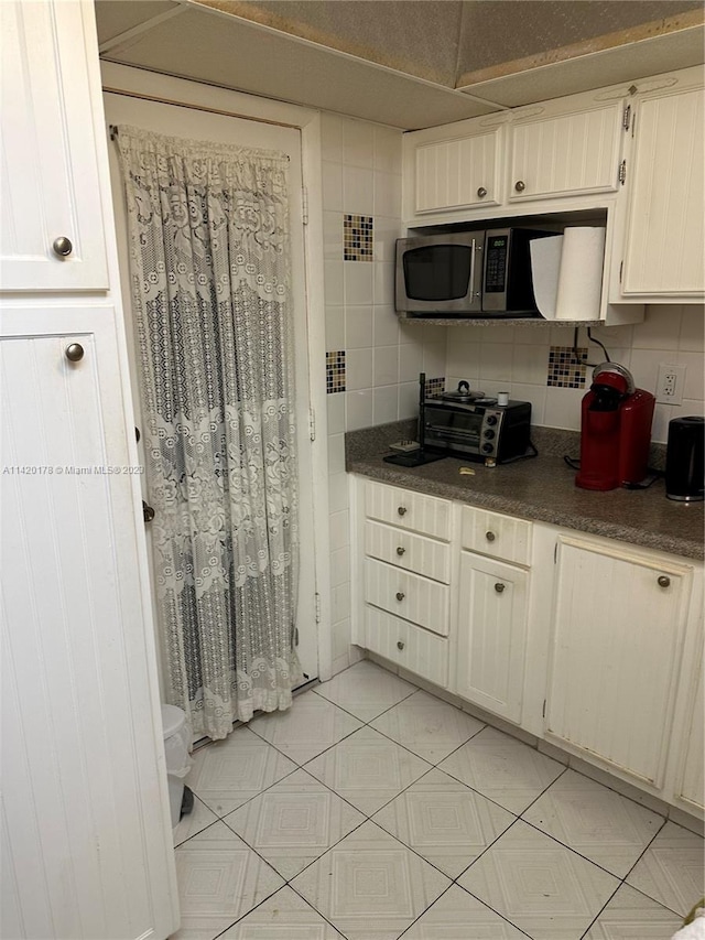 kitchen with white cabinets and backsplash