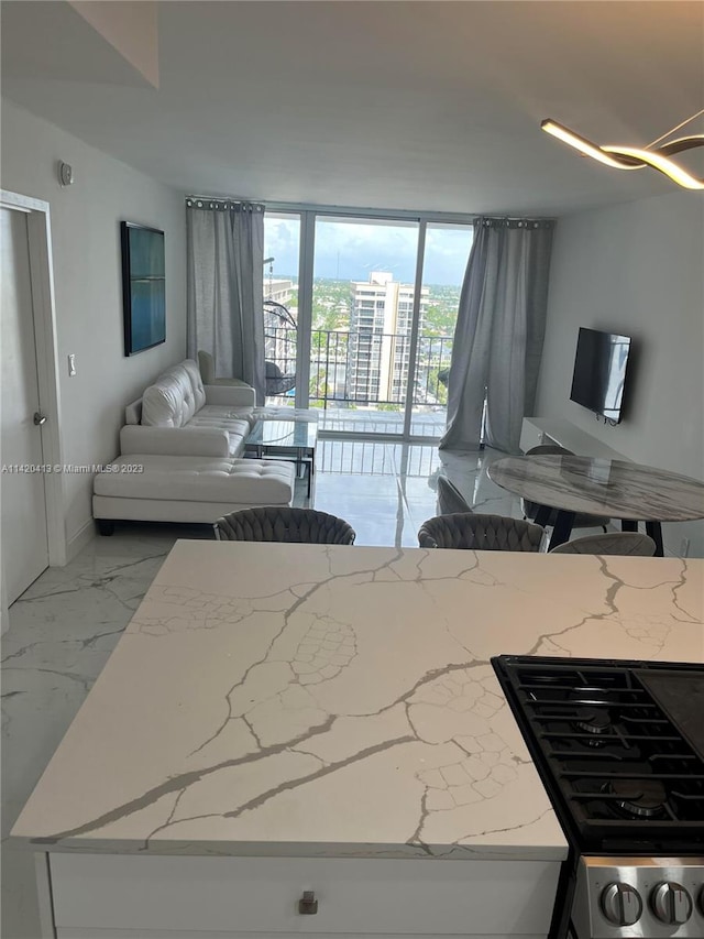 kitchen featuring light tile flooring, floor to ceiling windows, and light stone counters