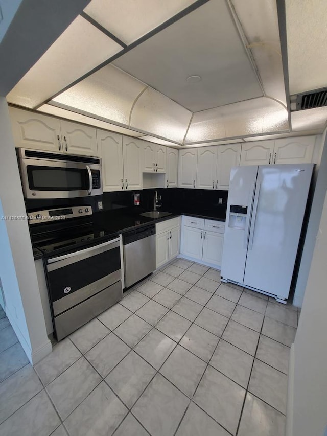 kitchen featuring white cabinets, light tile floors, appliances with stainless steel finishes, and sink