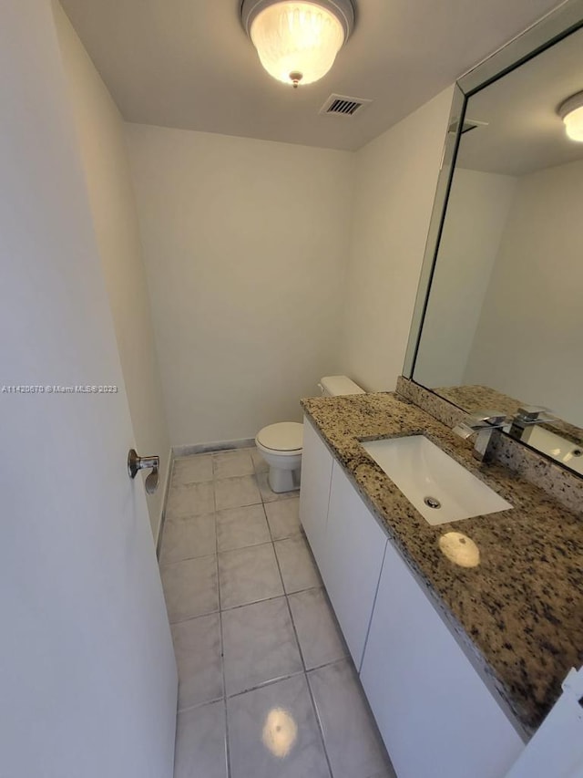 bathroom with toilet, tile floors, and vanity