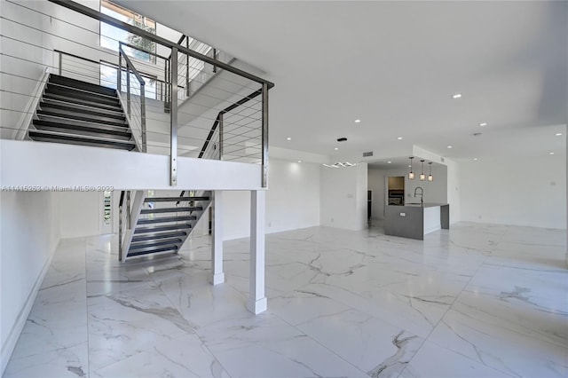 interior space featuring a high ceiling, sink, and light tile floors