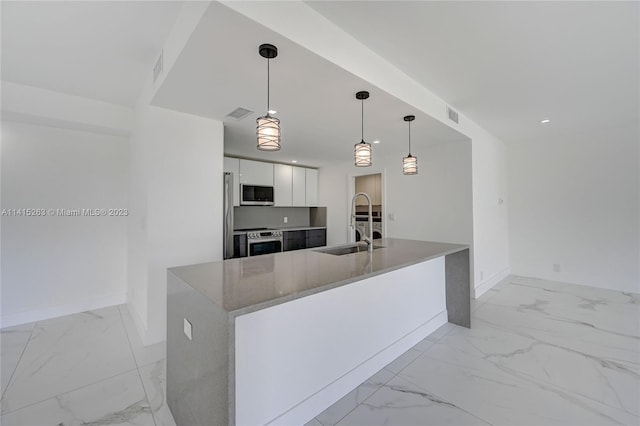 kitchen featuring white cabinetry, stainless steel appliances, pendant lighting, sink, and light tile floors