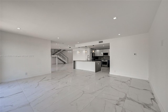 unfurnished living room featuring sink and light tile flooring