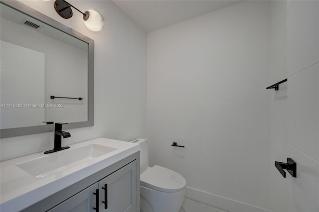 bathroom with tile flooring, vanity, and toilet