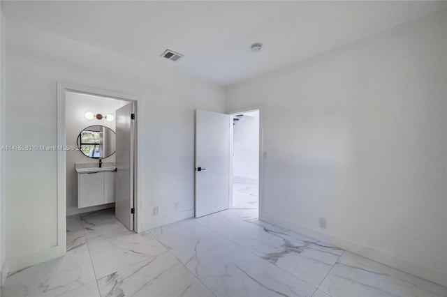 unfurnished bedroom featuring ensuite bath and light tile floors