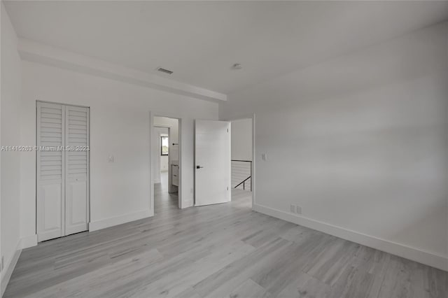 unfurnished bedroom featuring a closet and light hardwood / wood-style flooring