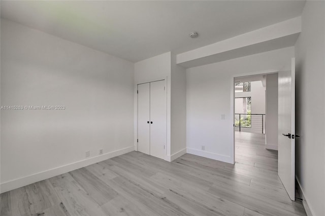 unfurnished bedroom with a closet and light hardwood / wood-style flooring