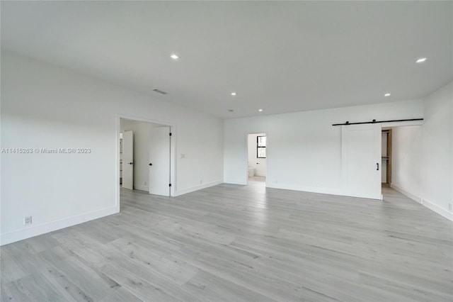 interior space featuring a barn door and light hardwood / wood-style flooring