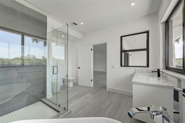 full bathroom featuring independent shower and bath, wood-type flooring, vanity, and toilet