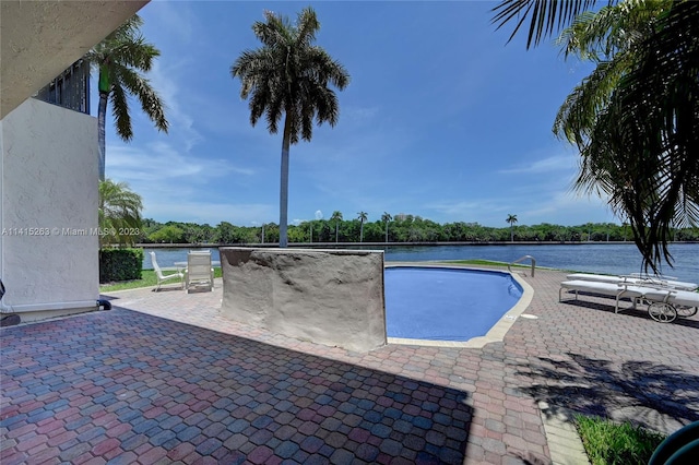 view of pool featuring a patio area and a water view