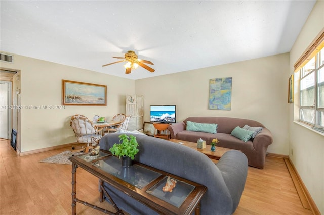 living room featuring light hardwood / wood-style flooring and ceiling fan