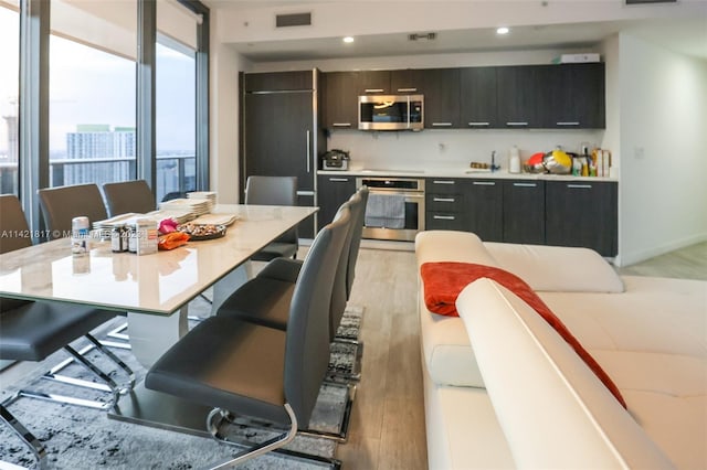 dining area featuring floor to ceiling windows and light hardwood / wood-style floors