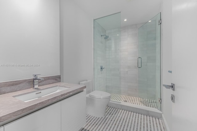 bathroom featuring tile patterned floors, a shower with shower door, toilet, and vanity