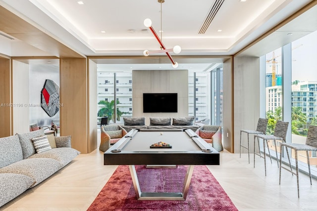 rec room with a tray ceiling, expansive windows, and billiards