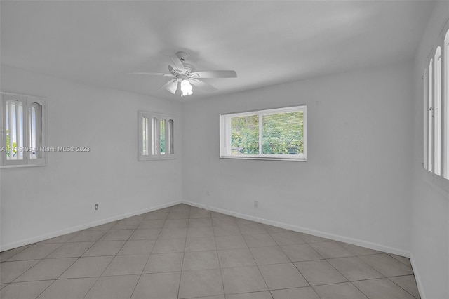 tiled spare room with ceiling fan