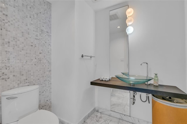 bathroom featuring tile walls, sink, tile flooring, and toilet