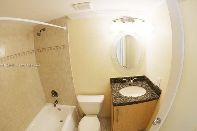 full bathroom with toilet, tile floors, tiled shower / bath combo, and vanity