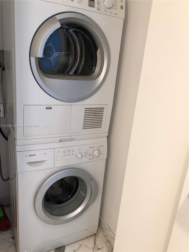 washroom with stacked washing maching and dryer