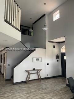 stairs with a towering ceiling and wood-type flooring