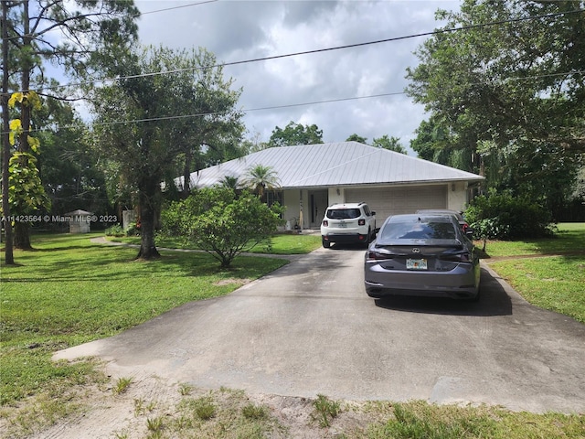 ranch-style house featuring a garage and a front lawn