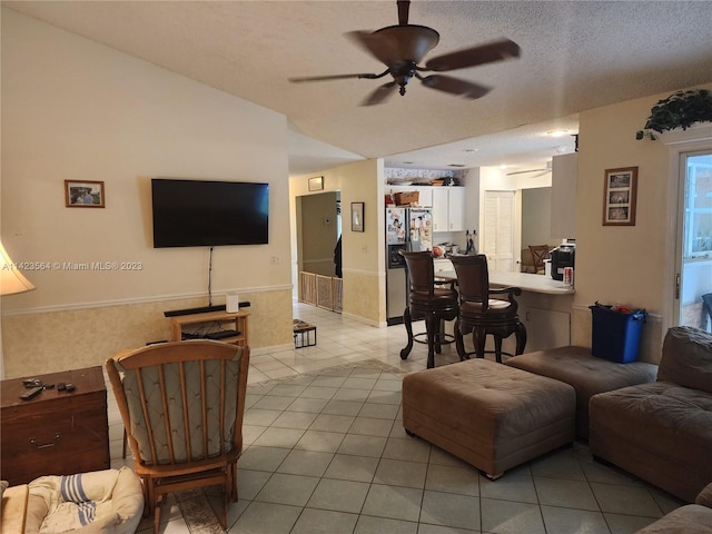 tiled living room featuring a textured ceiling and ceiling fan