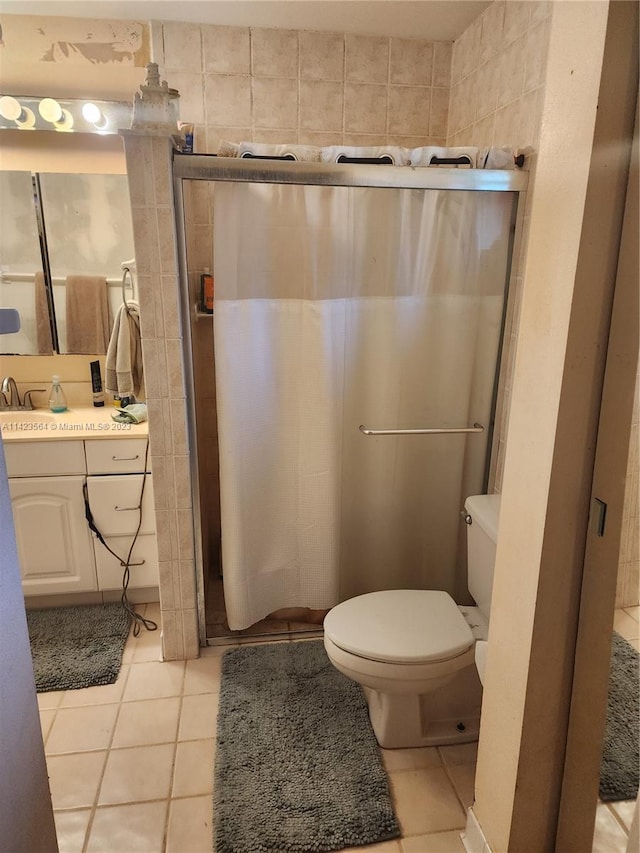 bathroom featuring vanity, tile walls, toilet, and tile patterned floors