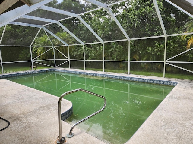 view of pool with a patio area and glass enclosure