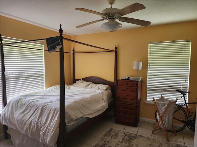 bedroom with tile patterned flooring, multiple windows, and ceiling fan