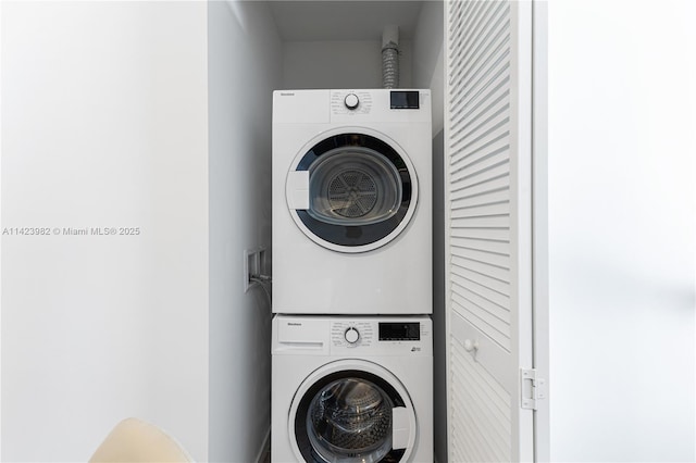 clothes washing area featuring stacked washer and dryer