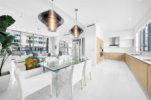 dining room featuring light tile patterned flooring, sink, and a wealth of natural light