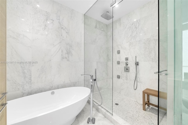 bathroom featuring separate shower and tub and tile walls