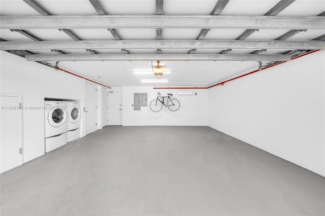 garage with electric panel and washer and dryer