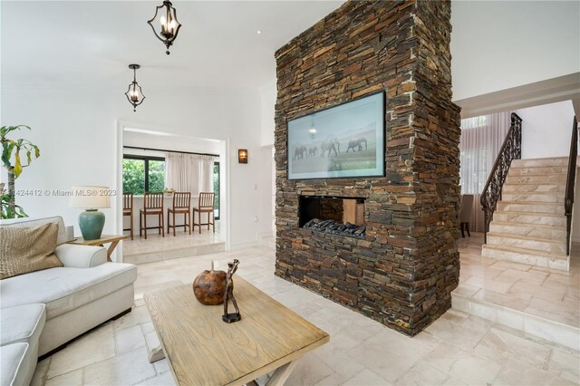 tiled living room featuring a notable chandelier and a stone fireplace