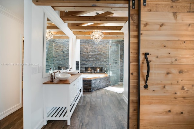 bathroom with beamed ceiling, vanity, hardwood / wood-style flooring, and a bath