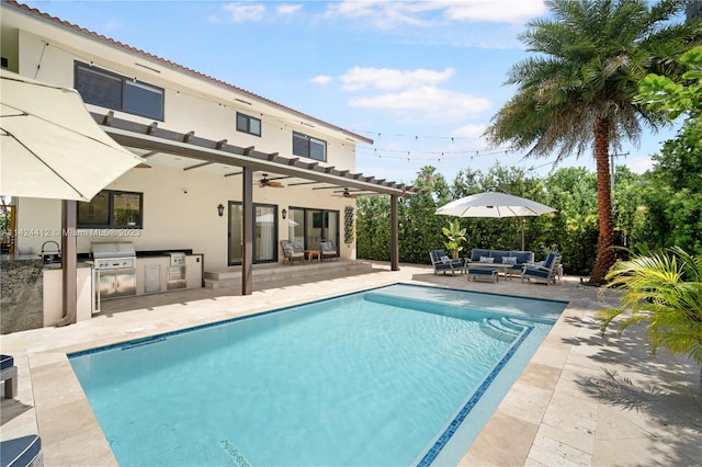 view of pool with grilling area, a patio area, exterior kitchen, outdoor lounge area, and ceiling fan