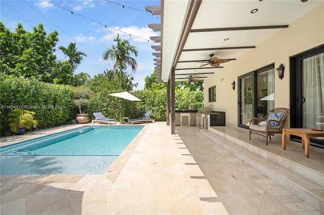 view of swimming pool with ceiling fan and a patio area