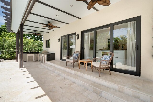 view of patio / terrace featuring ceiling fan, a grill, and an outdoor kitchen