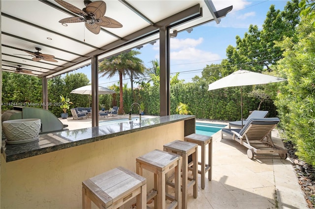 view of patio featuring a bar and ceiling fan