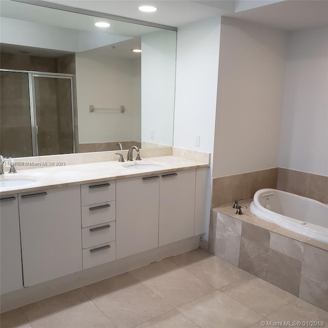 bathroom featuring shower with separate bathtub, dual sinks, tile flooring, and vanity with extensive cabinet space