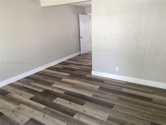 unfurnished room with dark hardwood / wood-style flooring