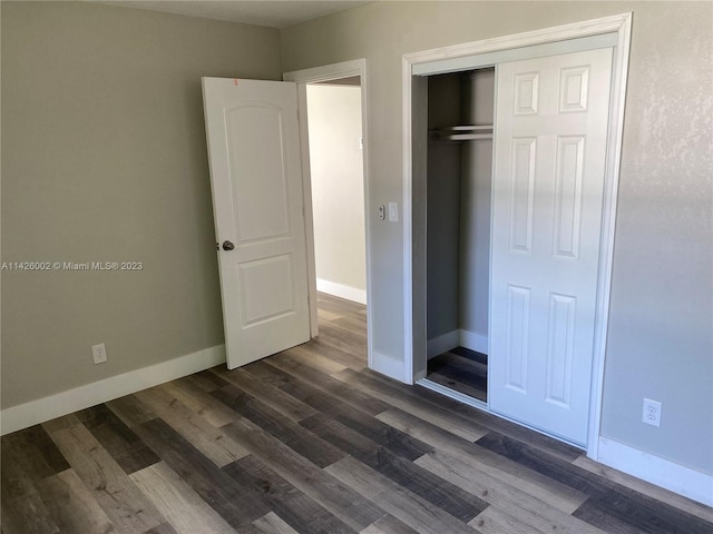 unfurnished bedroom with a closet and dark hardwood / wood-style floors