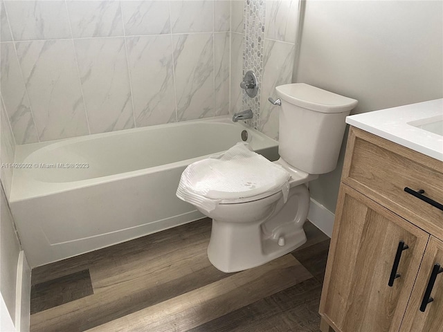 full bathroom featuring vanity, wood-type flooring, toilet, and tiled shower / bath