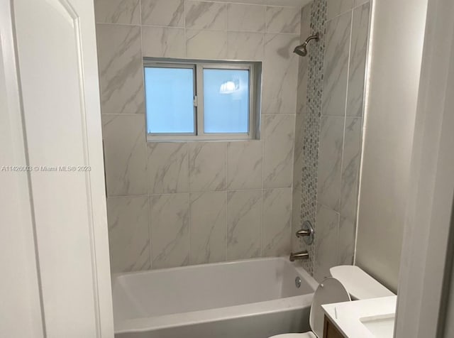 full bathroom with tiled shower / bath combo, toilet, and vanity