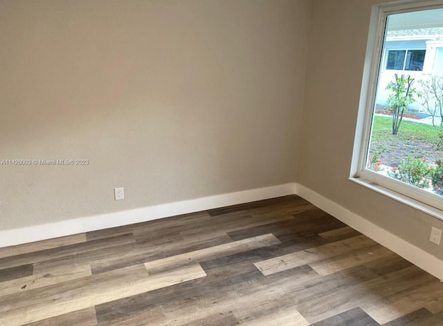 unfurnished room with dark wood-type flooring