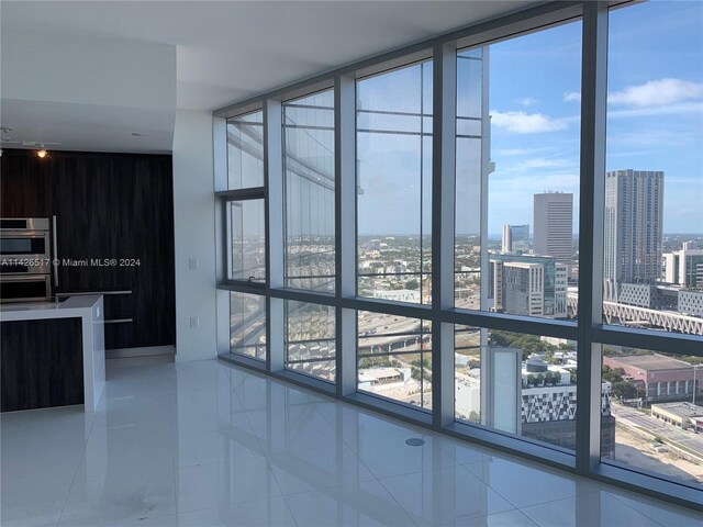 interior space featuring expansive windows, double wall oven, and tile patterned flooring