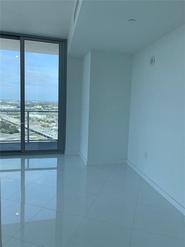 tiled spare room with expansive windows