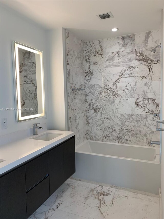 bathroom featuring vanity, tile patterned floors, and tiled shower / bath