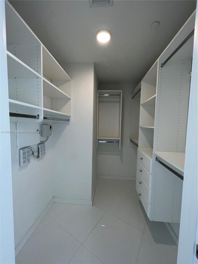 spacious closet with light tile patterned floors